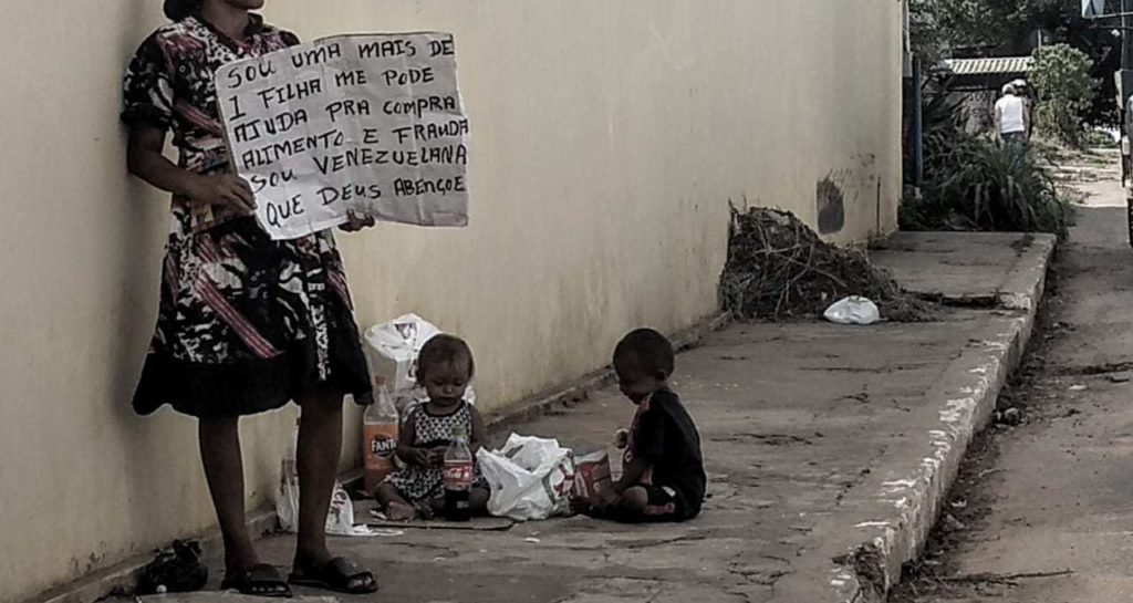 Imagem do dia: mãe e filhos venezuelanos pedem comida em Rio Branco