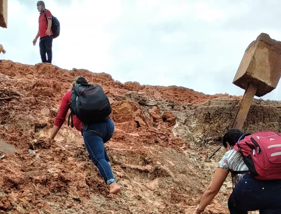 Professores escalam barranco para conseguir trabalhar após erosão acabar com acesso a porto em Cruzeiro do Sul