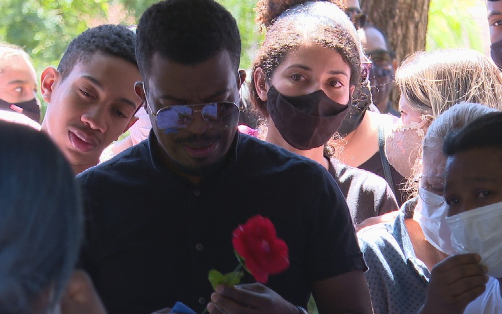 Cantor Delino Marçal se emociona em enterro da mãe que foi espancada até a morte em igreja de Goiânia