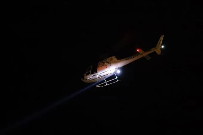Policiais usam helicóptero com farol de busca enquanto procuram por detento foragido